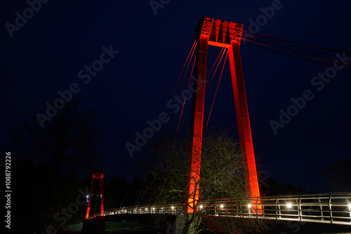 Valmiera,Latvia-November 15,2024-red white pink bridge in the dark late autumn night photo