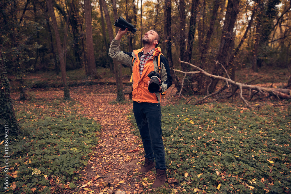 Man using binoculars and camera for bird and animal watching in nature. Man using binoculars and camera for bird and animal watching in nature.