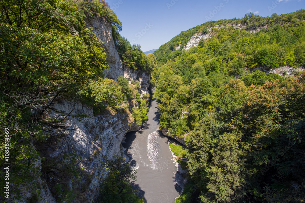 Argun Gorge, Chechen Republic (Chechnya), Russia. Top view of the Argun River flowing in a gorge among the rocks. Summer landscape with a mountain river. Natural landmark. Travel in the North Caucasus Argun Gorge, Chechen Republic (Chechnya), Russia. Top view of the Argun River flowing in a gorge among the rocks. Summer landscape with a mountain river. Natural landmark. Travel in the North Caucasus
