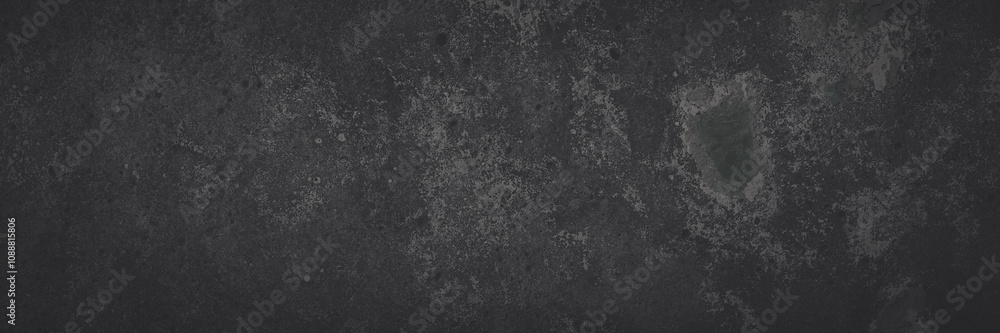 Fototapeta premium Dark wide panoramic background. Peeling paint on a concrete wall. Faded dark texture of old cracked flaking paint. Weathered rough painted surface with patterns of cracks. Shaded background for design
