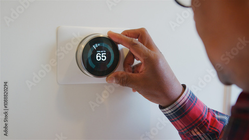 Fotografie Close Up Of Senior Man Setting Digital Smart Heating Thermostat At Home
