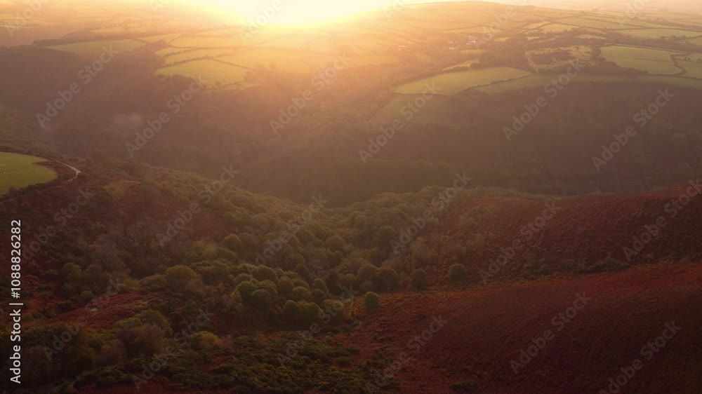 Sunrise Sun Flare Aerial View Over Exmoor Farm Fields with Rolling Hills and Trees Deep in the Valley. Golden Hour Spiritual Travel Footage 4K. Sunrise Sun Flare Aerial View Over Exmoor Farm Fields with Rolling Hills and Trees Deep in the Valley. Golden Hour Spiritual Travel Footage 4K.