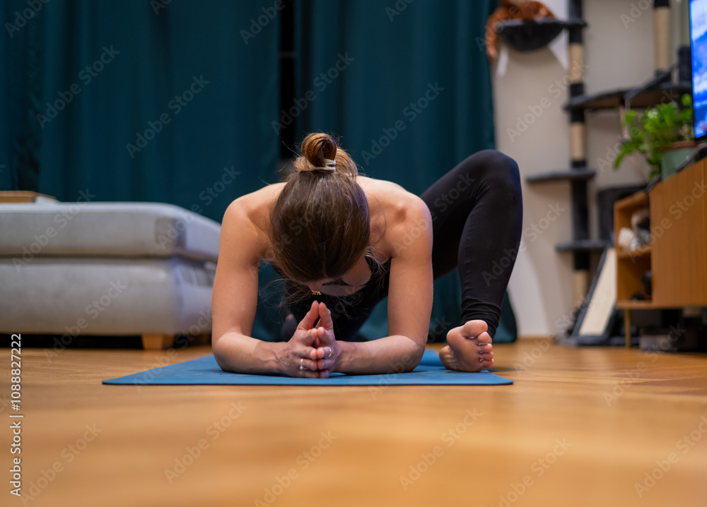A woman practices yoga at home on a yoga mat in Lizard Pose. Utthan Pristhasana. woman in center of photo. A woman practices yoga at home on a yoga mat in Lizard Pose. Utthan Pristhasana. woman in center of photo.