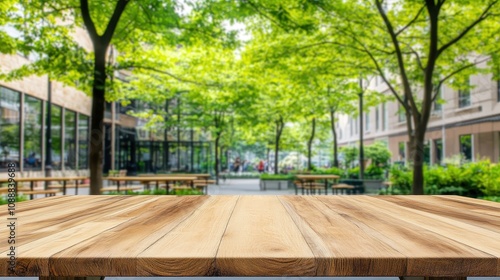 Fototapeta Naklejka Na Ścianę i Meble -  Empty wooden table in a park with blurred background of city street and green trees.