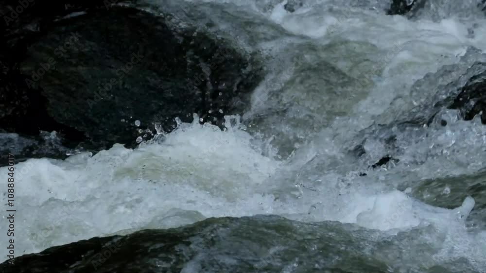 The splash of fast river water over the rocks. The fast flow of river water. The water looks clean and fresh. The surface of the river water. Natural light, real time The splash of fast river water over the rocks. The fast flow of river water. The water looks clean and fresh. The surface of the river water. Natural light, real time