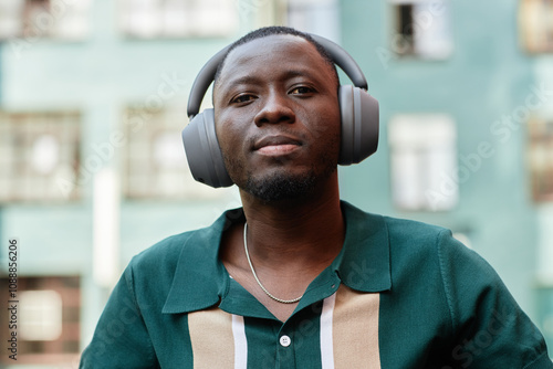 Photos Close up portrait of Black man wearing headphones and listening to music in urba