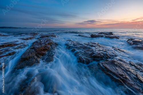 Dawn view on the rocky shore coastline.