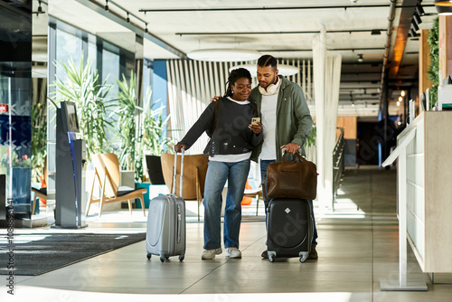 Canvas Print A young couple joyfully arrives at a modern hotel lobby, eager to start their vacation filled with adventure