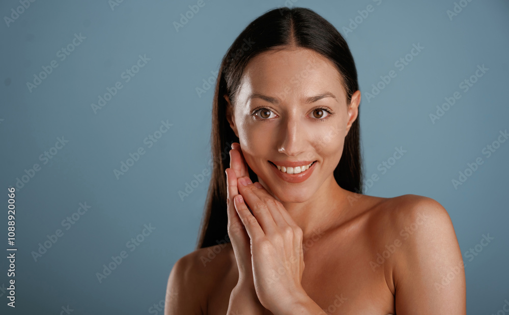 Front view, portrait. Young woman is in the studio against background Front view, portrait. Young woman is in the studio against background