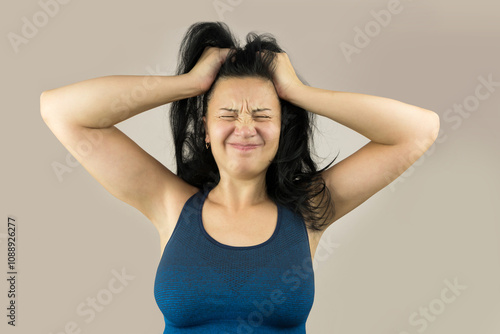 Disappointed and irritated woman with closed eyes holding her head, isolated on white background.