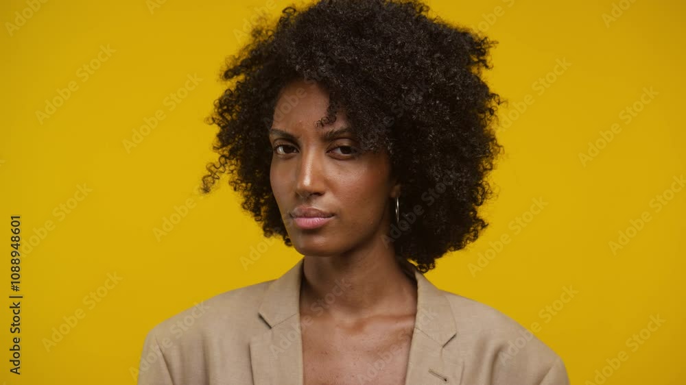 Woman Shaking Head in Disapproval Against Yellow Background Woman Shaking Head in Disapproval Against Yellow Background