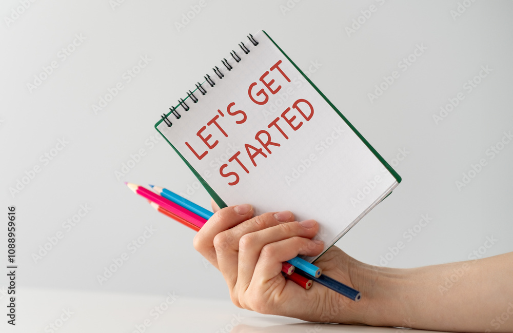 The girl holds a business card with Let's Get Started The girl holds a business card with Let's Get Started