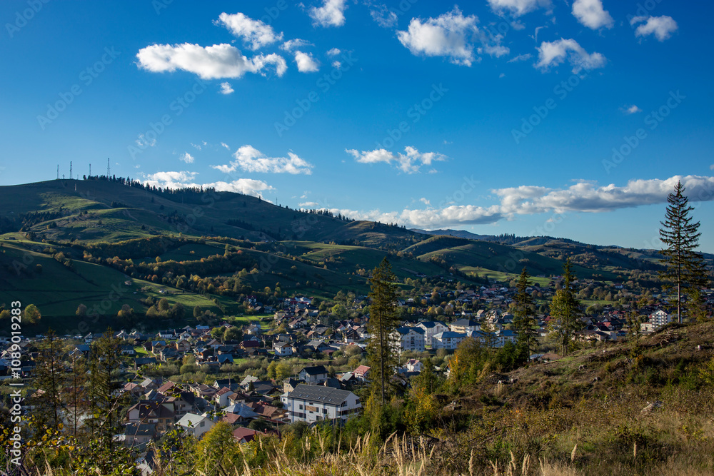 Fototapeta premium landscape of Gura Humorului Romania, with hills and houses at sunset