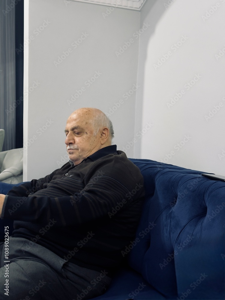 An octogenarian grandfather sits on the sofa after dinner
An octogenarian grandfather sits on the sofa after dinner