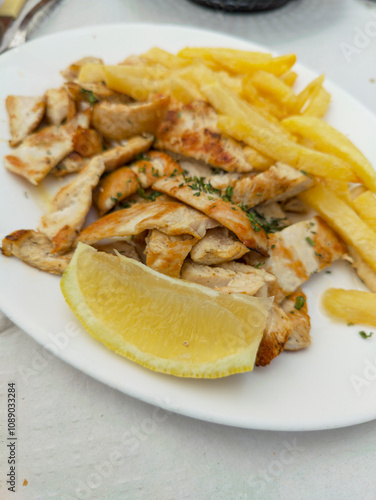 Grilled Chicken and French Fries Served on a Sunny Terrace in Málaga