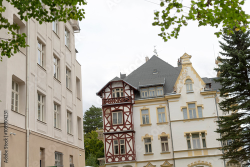 The vibrant city showcases mixed architectural styles, prominently a traditional German halftimbered house, beautifully juxtaposed with sleek modern structures enhancing the landscape photo