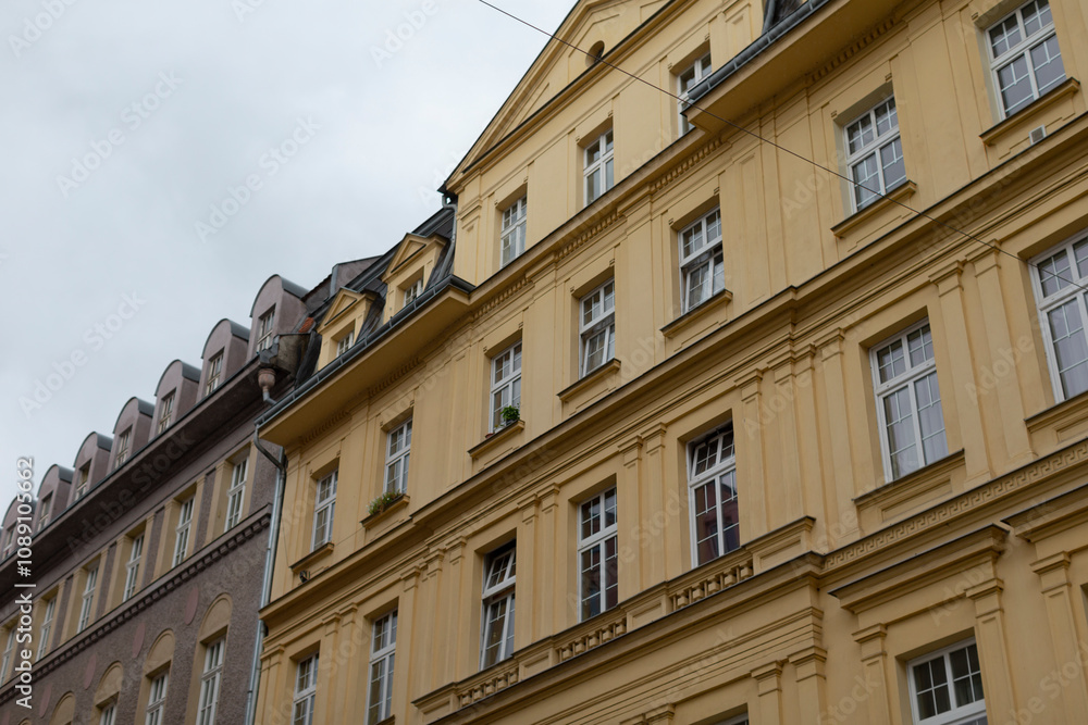 Fototapeta premium The elegant and eyecatching exterior of a yellow apartment building boasts intricate and decorative details, beautifully situated within a vibrant and dynamic cityscape full of charm and energy