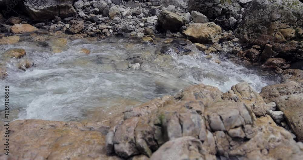 Mountain stream with crystal-clear water rushes over and around rocks, creating a tranquil and dynamic scene of untouched nature Mountain stream with crystal-clear water rushes over and around rocks, creating a tranquil and dynamic scene of untouched nature