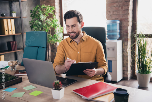 Photo of nice young male work papers paperholder wear yellow shirt formalwear coworking successful businessman nice light office photo