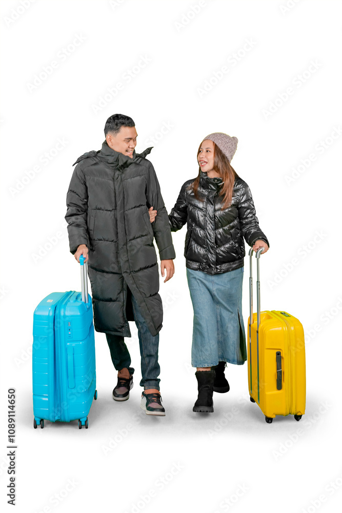 Couple Traveling in Winter Clothing with Colorful Luggage, Smiling and Walking Together Couple Traveling in Winter Clothing with Colorful Luggage, Smiling and Walking Together
