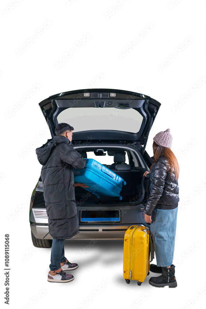 Couple Loading Suitcase into Car Trunk for Winter Travel Couple Loading Suitcase into Car Trunk for Winter Travel
