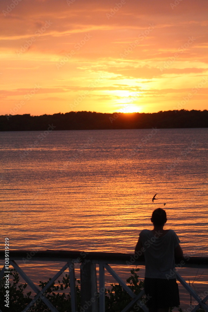 Fototapeta premium mulher apreciando o por do sol na praia do jacaré, cabedelo, paraíba
