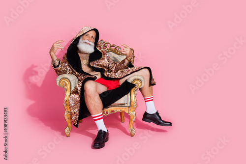 Full body portrait of extravagant egocentric man sit throne weal leopard coat hood empty space isolated on pink color background