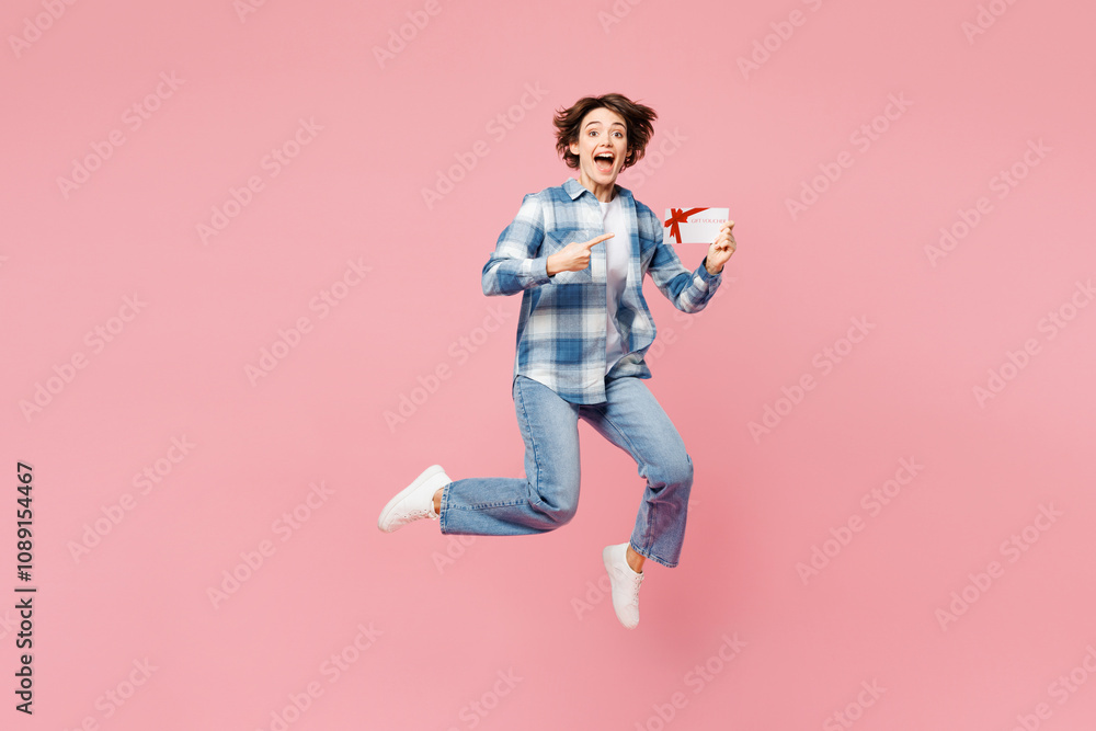 Full body young happy woman she wear blue shirt white t-shirt casual clothes jump high hold gift certificate coupon voucher card for store isolated on plain light pink background. Lifestyle concept. Full body young happy woman she wear blue shirt white t-shirt casual clothes jump high hold gift certificate coupon voucher card for store isolated on plain light pink background. Lifestyle concept.