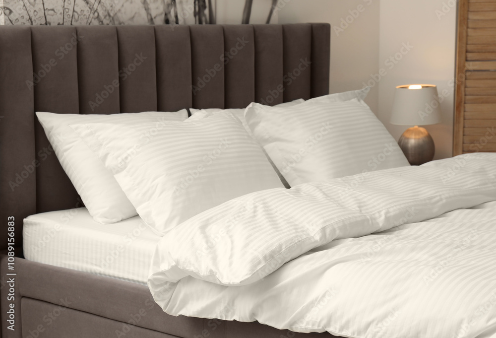 Obraz premium Comfortable bed with clean linens and pillows indoors