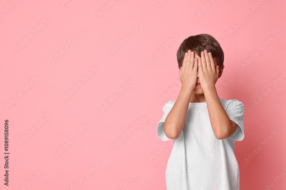 Scared little boy covering face on pink background. Space for text Scared little boy covering face on pink background. Space for text