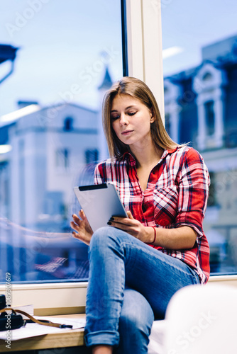 Free Download Thinking female creative employee share editing photos in blog via portable pc working with multimedial late in office, pensive student sitting on window sill read ebook prepare for exams in college - GFXLoad