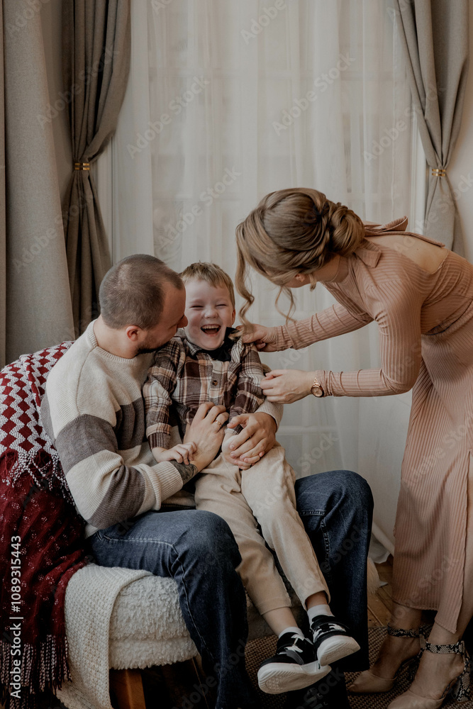 Naklejka premium Family parents with young son at home having fun and laughing