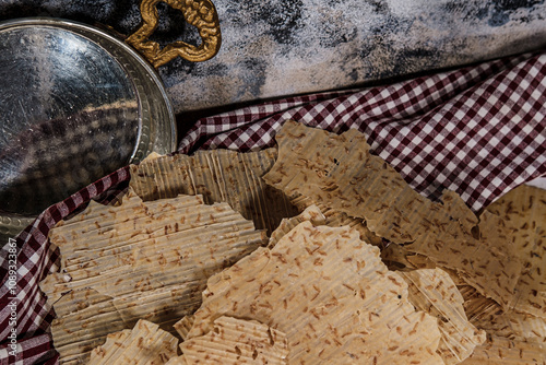 Tarhana cips, crispy snacks a traditional turkish anatolian fermented soup base made into crunchy chips made of youghurt and cereals, served with brass kitchenwear photo