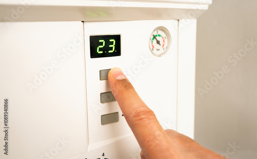 The man uses the keys to activate the natural gas boiler photo