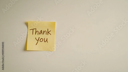 Simple note expressing gratitude on a sticky pad placed on a wall photo