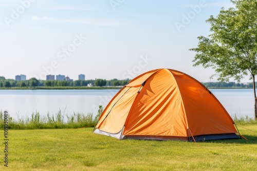 Eye catching orange tent near serene lake under clear blue sky on a delightful summer day