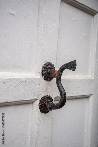 Old iron door handle on a white door photo