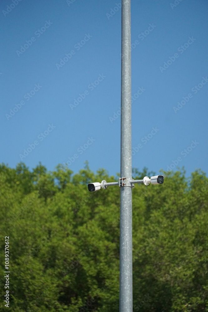 Surveillance cameras monitoring urban green spaces outdoor setting photography nature background high angle security awareness Surveillance cameras monitoring urban green spaces outdoor setting photography nature background high angle security awareness