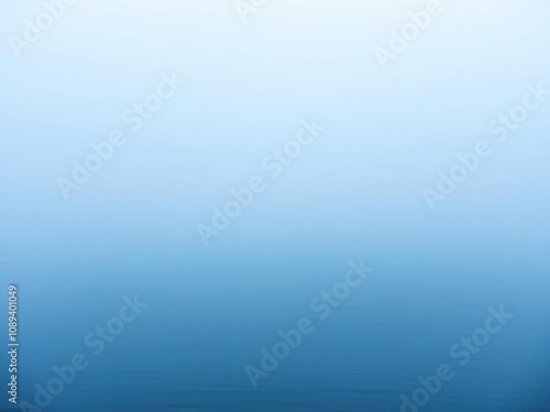 Light blue misty fog rolling in over a calm lake with a silky smooth surface and clear water, still water, peaceful lake scene