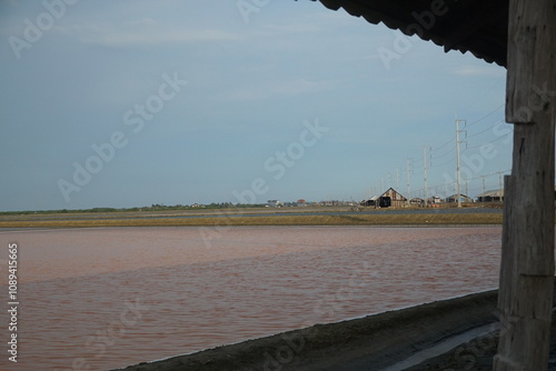Exploring tranquil landscapes salt flats and rustic structures coastal area photography serene environment wide-angle view nature's beauty