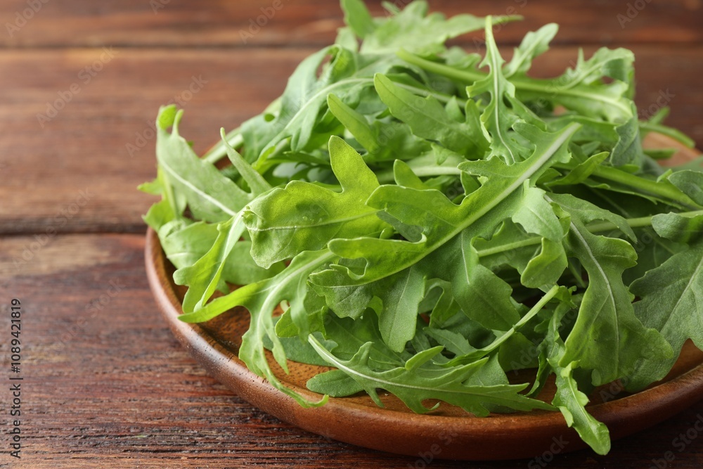 Fresh green arugula leaves on wooden table, closeup Fresh green arugula leaves on wooden table, closeup