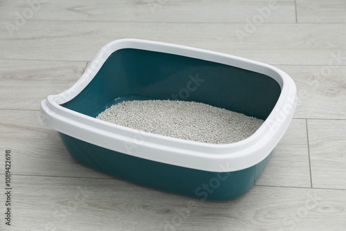 Cat tray with clumping litter on floor indoors photo