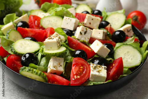 Delicious salad with feta cheese on grey table, closeup