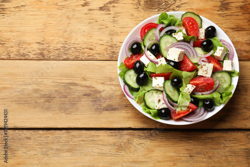 Delicious salad with feta cheese on wooden table, top view. Space for text