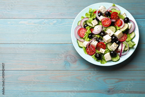 Delicious salad with feta cheese on blue wooden table, top view. Space for text