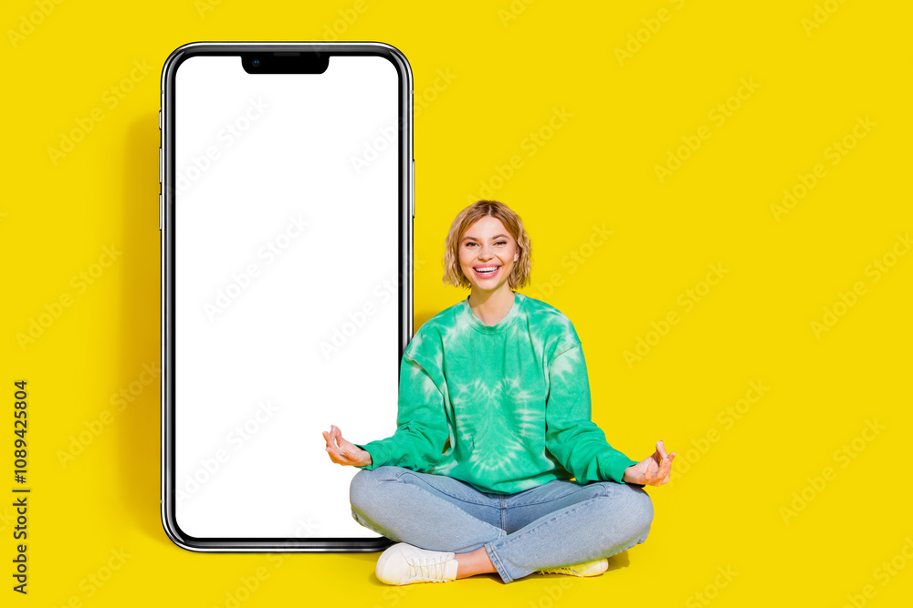 Full length photo of shiny attractive lady dressed tie dye sweatshirt practcing yoga modern gadget empty space isolated yellow color background Full length photo of shiny attractive lady dressed tie dye sweatshirt practcing yoga modern gadget empty space isolated yellow color background