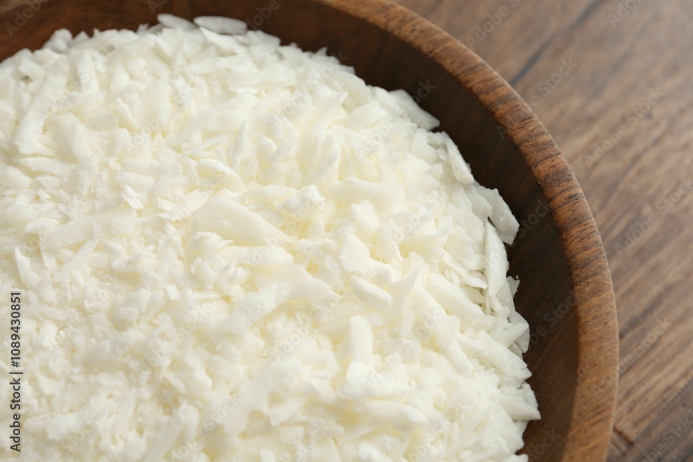 White soy wax flakes in bowl on wooden table, closeup White soy wax flakes in bowl on wooden table, closeup