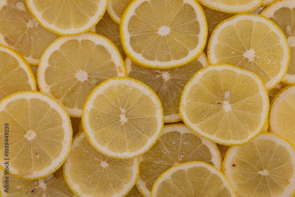 Yellow sliced lemons places on a table overlapping each other. Background texture of fresh yellow fruit. Yellow sliced lemons places on a table overlapping each other. Background texture of fresh yellow fruit.