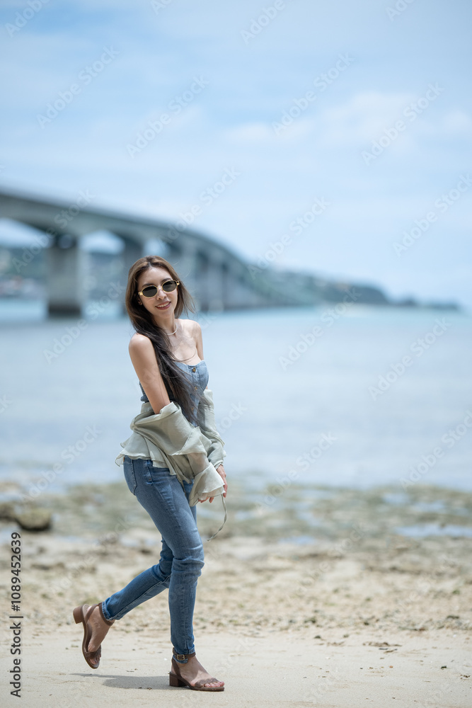 Woman relaxing on tropical beach with Kouri bridge background. Okinawa Woman relaxing on tropical beach with Kouri bridge background. Okinawa