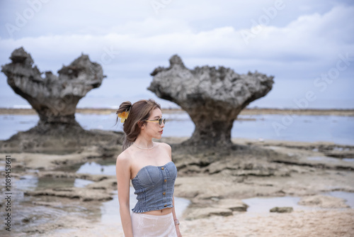 Woman enjoy view of Heart rocks on Okinawa Prefecture Kouri Island, japan. photo